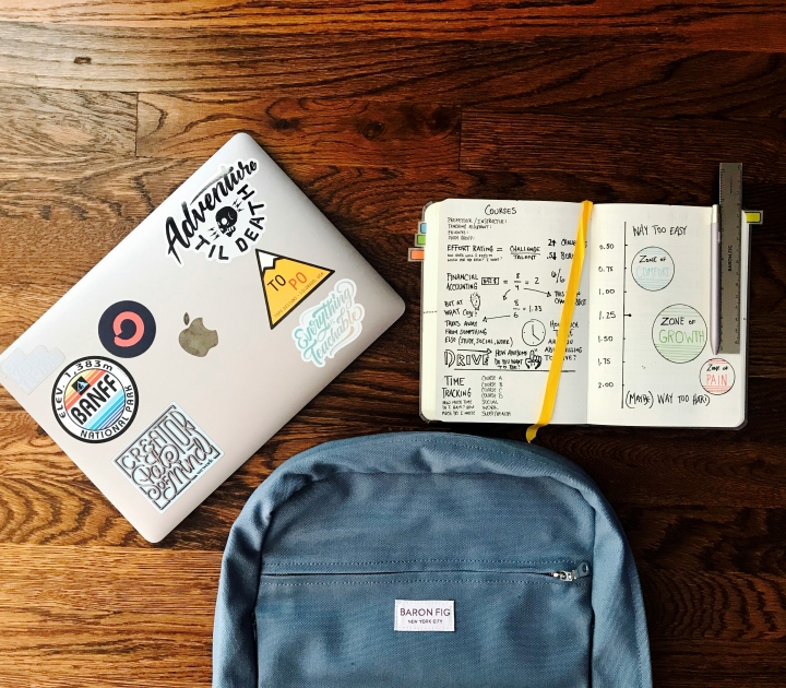 a laptop, a backpack, and a notebook