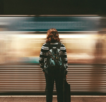 Person standing in front of passing subway train